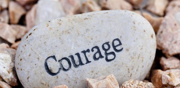 close up of 'courage' stone on textured stone background